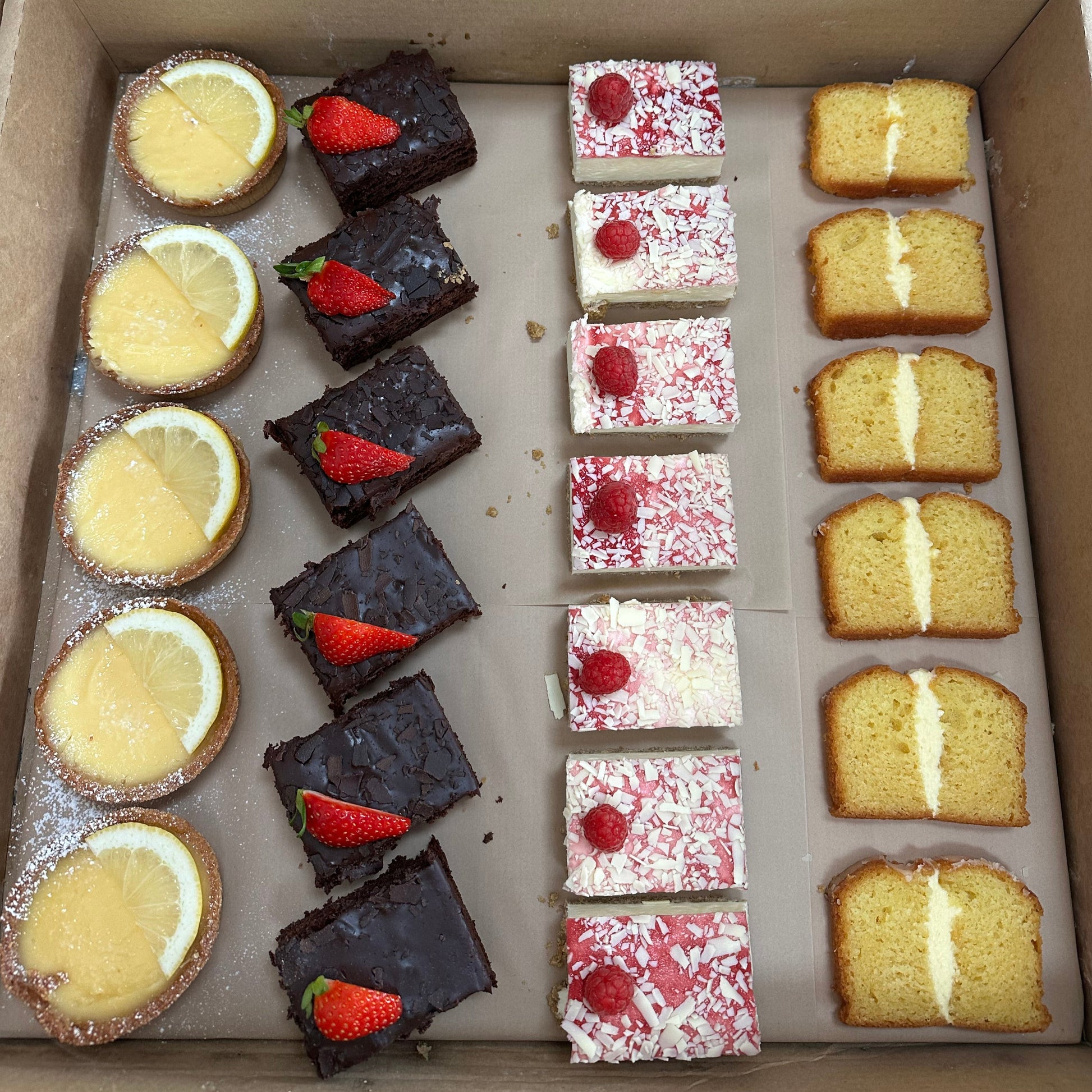 Assorted desserts and cakes, lemon tarts, raspberry cheesecake, sponge cake 